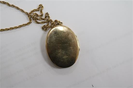 An engraved 9ct gold oval locket on a 9ct chain, locket 4cm.